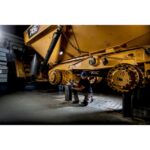 Projecteur LED sans fil pour chantier éclairant une machine lourde avec batterie compacte