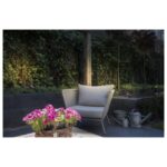 Spot extérieur sur piquet rouille IP65 dans un jardin près d un fauteuil et de fleurs