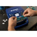 Main installant un consommable dans l’étiqueteuse ouverte