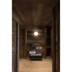 Plafonnier allumé dans un intérieur habillé de bois