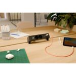 Bloc noir sur un plateau avec téléphone et cordons branchés