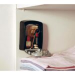 Rangement mural ouvert dans un placard, contenant des clés et petits objets près de linge plié