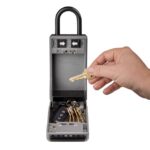 Main plaçant une clé dans le bac d’une boîte portable ouverte