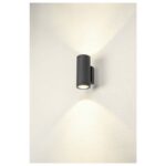 Applique sur mur clair diffusant deux cônes lumineux symétriques